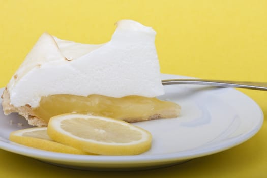 lemon meringue pie slices of lemon on a yellow background