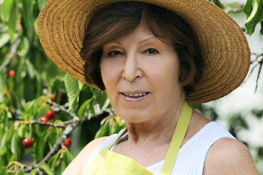 Portrait of a senior woman in a beautiful garden near a cherry tree