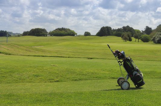 Golf equipment on a golf field in a cloudy day.