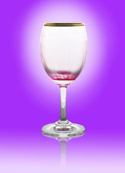 Red wine glass is empty on violet background