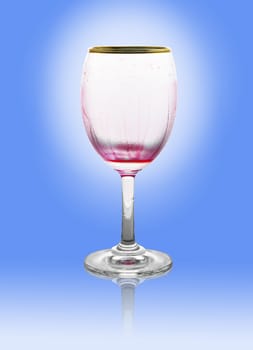 Red wine glass is empty on blue background