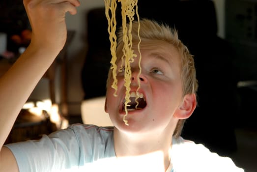 boy eating noodles. Please note: No negative use allowed.