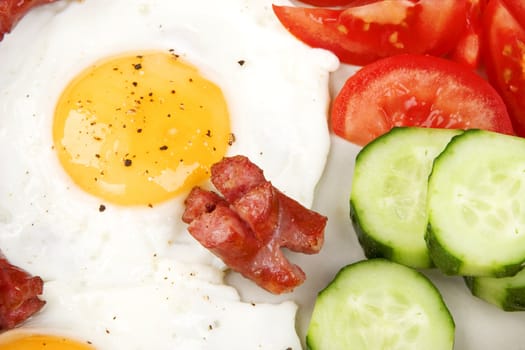 close-up of fried eggs with sausage and vegetables