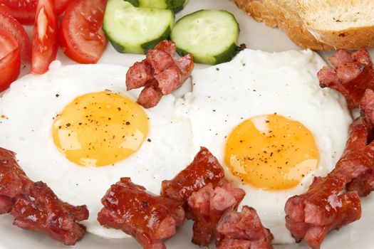 close-up of fried eggs with sausage and vegetables