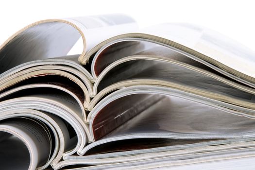 pile of old magazines with bending pages on white background