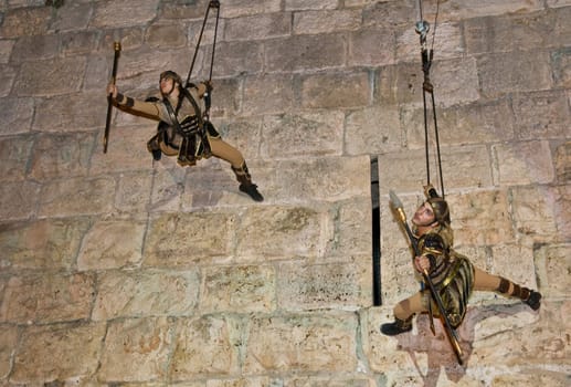 JERUSALEM - NOV 03 : An Israeli acrobats dressed as knight climbing on the old city walls in the annual medieval style knight festival held in the old city of Jerusalem on November 03 2011