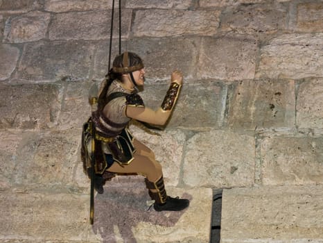 JERUSALEM - NOV 03 : An Israeli acrobat dressed as knight climbing on the old city walls in the annual medieval style knight festival held in the old city of Jerusalem on November 03 2011