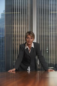 Business woman leaning on chair in boardroom looking at camera