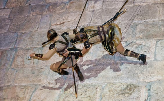 JERUSALEM - NOV 03 : An Israeli acrobats dressed as knight climbing on the old city walls in the annual medieval style knight festival held in the old city of Jerusalem on November 03 2011