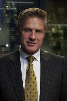 Portrait of a senior executive by a window smiling looking at camera