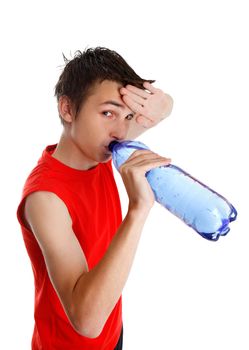 Teen boy wiping his brow and drinking water from a bottle.