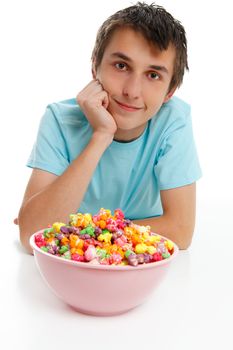 Smiling boy relaxing with a bowl of colourful popcorn.