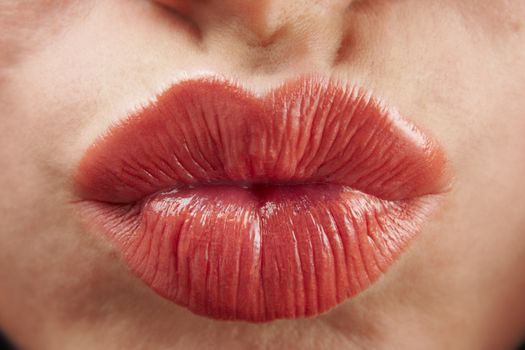 close up of womans pouting lips with red lipstick