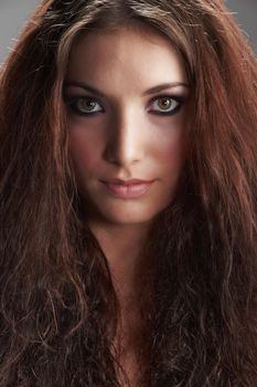 Portrait of beautiful young woman with make-up on grey background