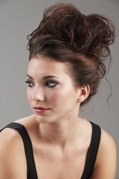 Portrait of beautiful young woman with make-up on grey background