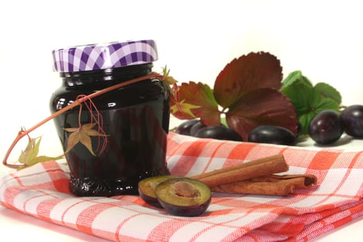 a glass of plum jam with fresh ingredients