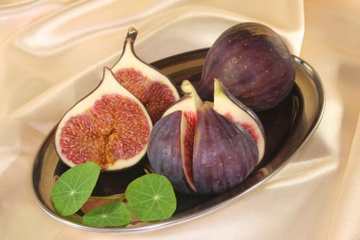 half figs with nasturtium on a silver platter