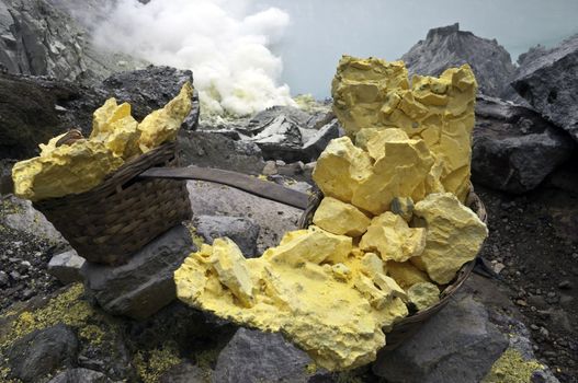 Basket full of sulfur nuggets atop a volcano in Indonesia