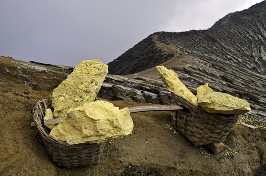 Basket full of sulfur nuggets atop a volcano in Indonesia