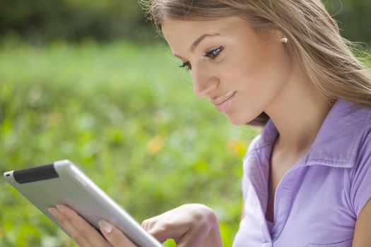 Beautiful Young Woman With Tablet Computer In Park