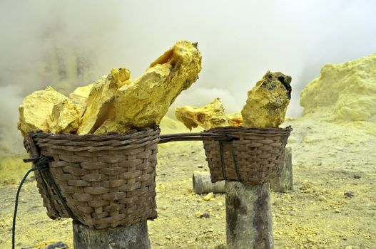 Basket full of sulfur nuggets atop a volcano in Indonesia