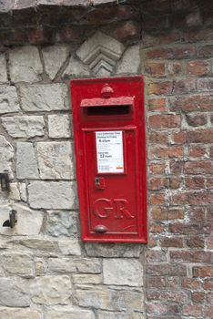 A Red British Post Box set in a stone wall