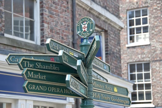 A necessity for tourists in the sidestreets of York an ornate green street signpost