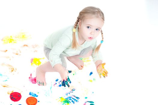 Studio shot of little girl playing with colors