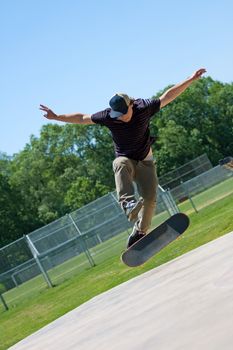 Action shot of a skateboarder doing tricks on his skateboard at the skate park.