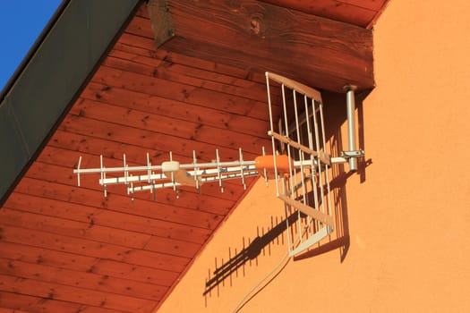 White modern antenna hanging on colored wall house