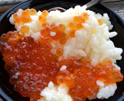 Rice with red caviar in black chalice