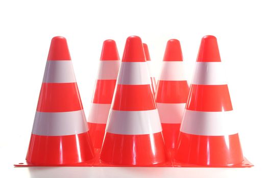 red and white construction pylons before a white background