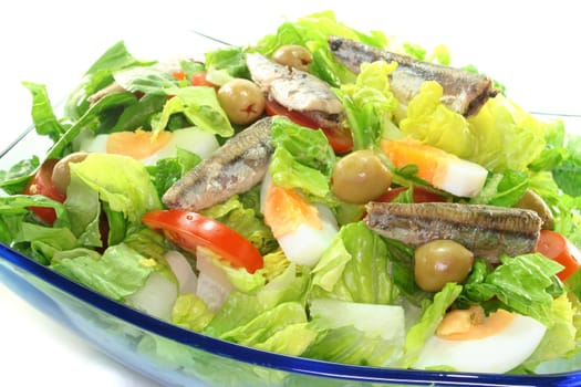 Chef salad with anchovies, egg, tomatoes, olives and salad leaves