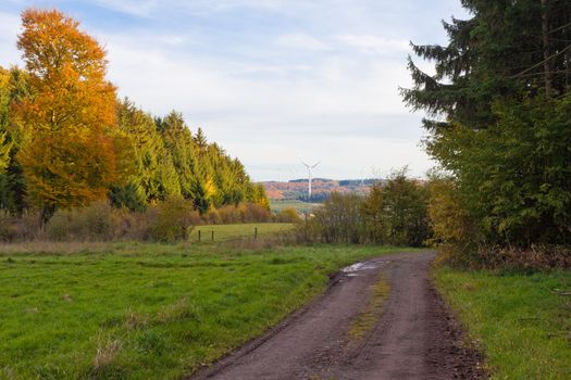 Landscape of Eifel region, Germany, farmland, forested rolling hills and modern wind turbines.