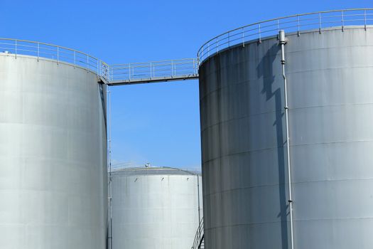 Big grey oil tanks and blue sky