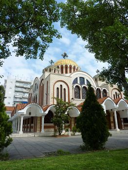 Church of Saints Cyril and Methodius in Thessaloniki, Greece, surrounded by trees by beautiful weather. Saints Cyril and Methodius were born in the 9th century in Thessaloniki, Greece, and were two Bizantine Greek brothers. Cyrillic alphabet, still used in slavic countries, is based on an alphabet they created.