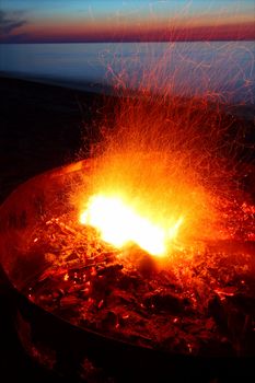 Blazing campfire at sunset along the beautiful beach of Lake Superior in northern Michigan.