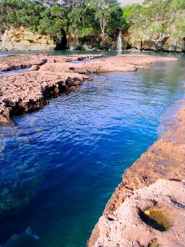 Waterfall flows into the ocean at Goat Island Marine Reserve on the North Island of New Zealand.