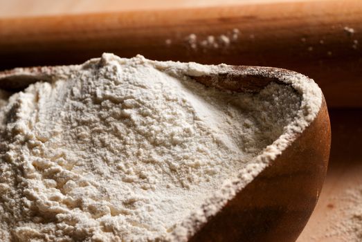 Wooden dough pin and baking flour with side lighting