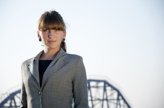 portrait of young business woman, a blue sky background and metal farm