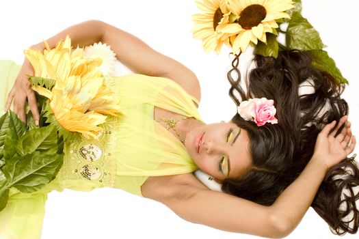 Studio portrait of an Indian  Indonesian beauty model lying on the floor with yellow flowers