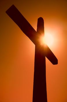 silhouette of the cross against the sun on the sky