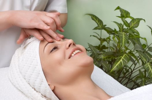 pretty woman getting facial massage in the beauty salon