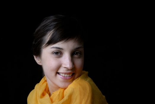 Portrait of a brunette young girl in black background