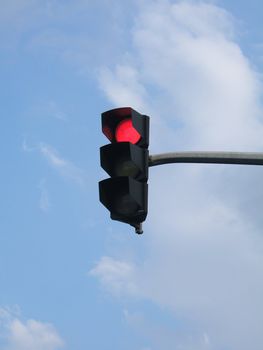 Traffic light with red light against the sky