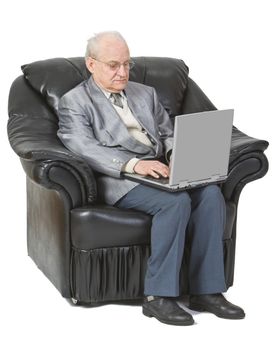 Image of a senior man siting in an armchair and using a laptop,isolated against a white background.