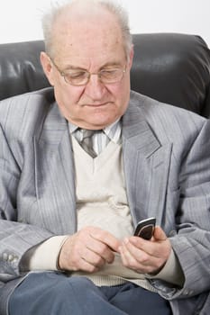 Close-up image of a senior man typing a message on his mobile phone.