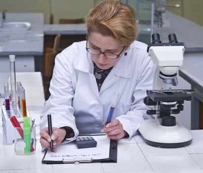 Female researcher taking notices at her workplace.All inscriptions are mine.