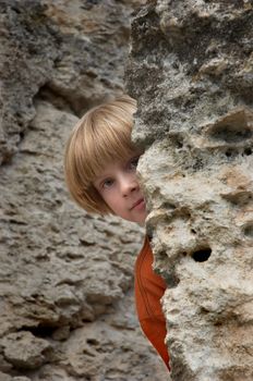 boy playng hide and seek game in the rocks