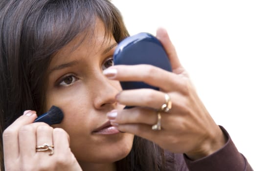 Closeup image of a woman applying powder on her face.